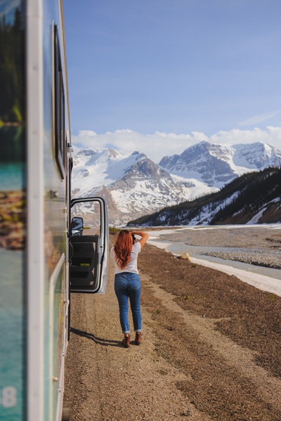 Frau macht Fotos von den schneebedeckten Bergen in Kanada