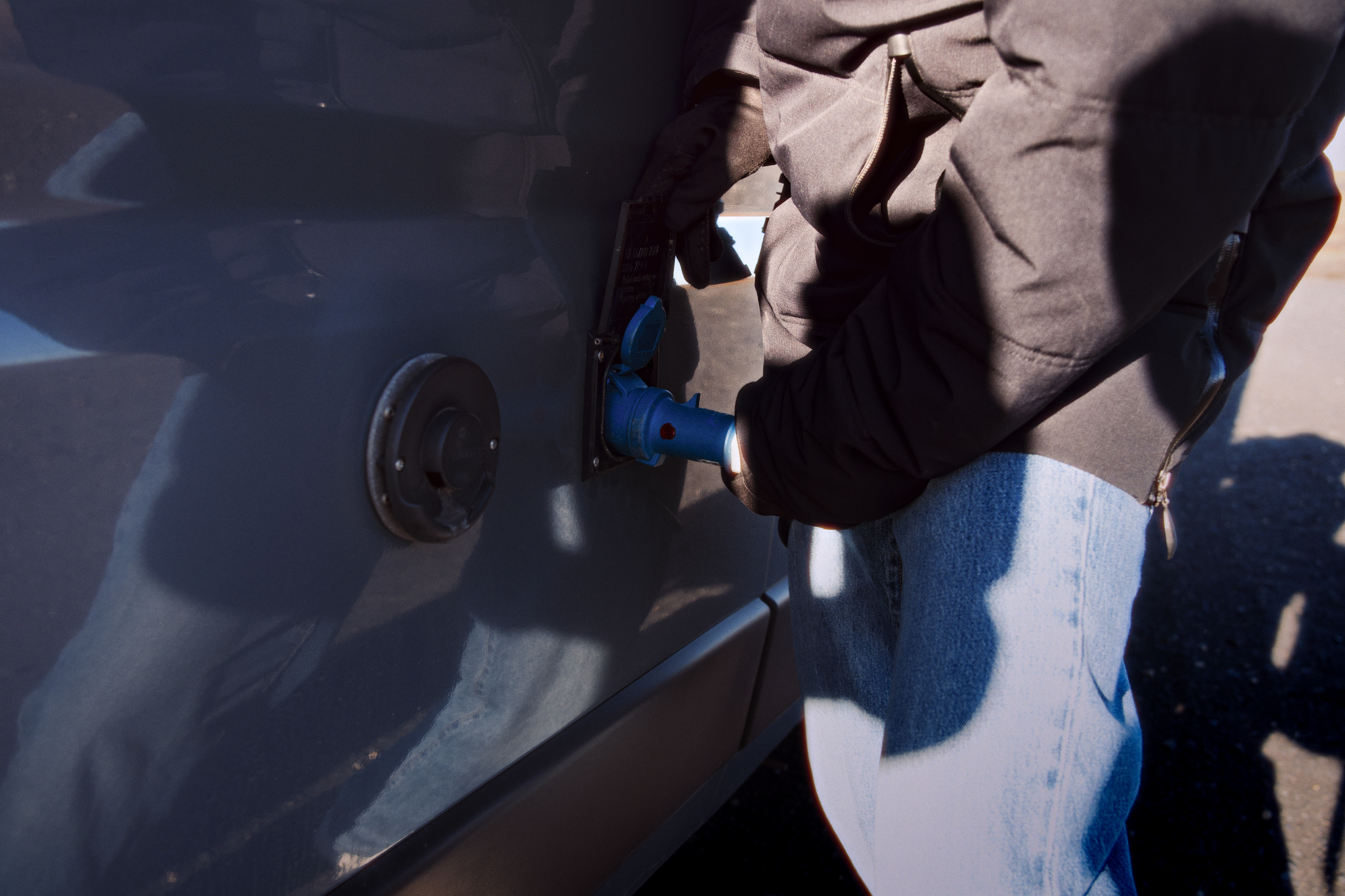 Mann schließt Wohnmobil am Strom an