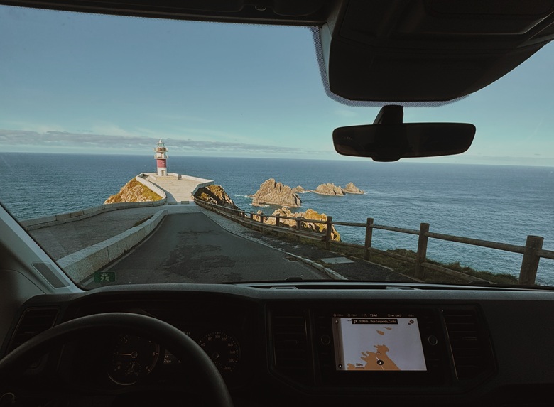 Blick aus dem Camper auf Leuchtturm und Meer in Spanien