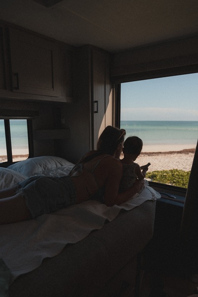 Frau mit Kind im Wohnmobil am Strand