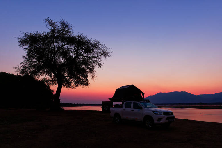 Camper mit Dachzelt vor Sonnenuntergang in Simbabwe