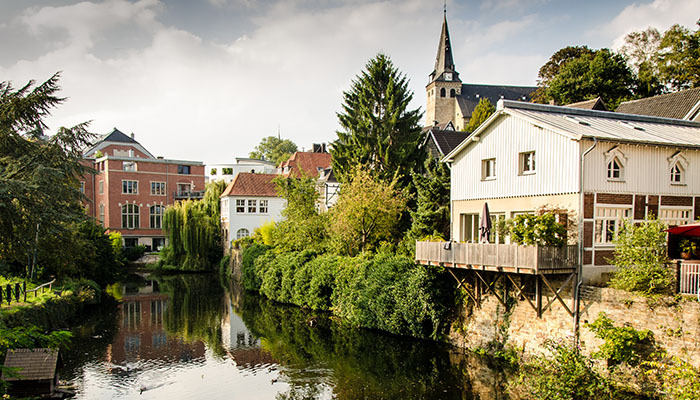 Gewässer in Essen-Kettwig mit einem Kirchturm im Hintergrund.