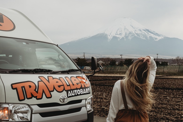 Frau bereist Japan mit dem Camper und schaut auf den Mount Fuji