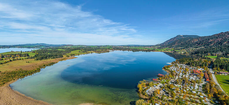 Wohnmobile an einem blauen See im Allgäu