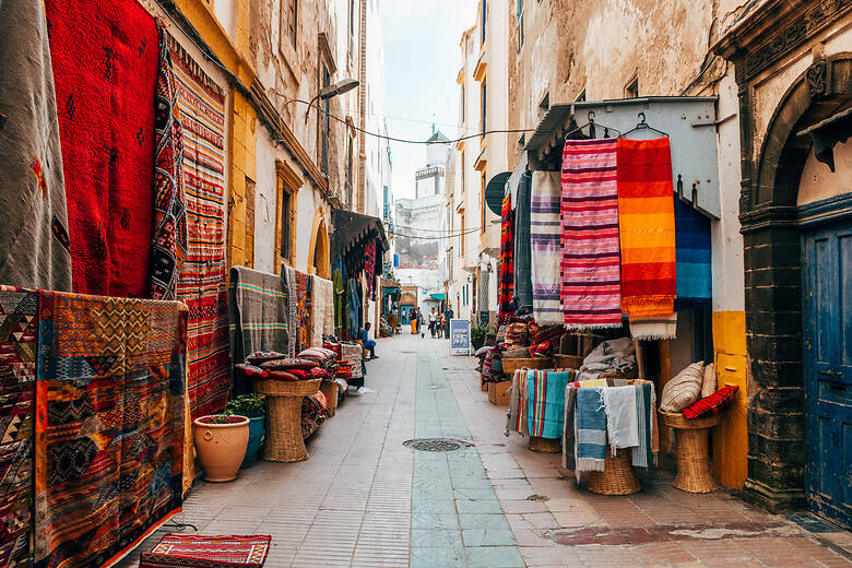 Markt mit bunten Teppichen in einer Gasse in Marokko