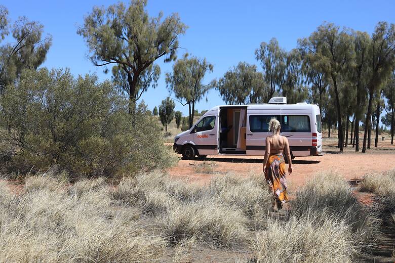 Frau mit dem Camper im Outback von Australien an einem sonnigen Tag 