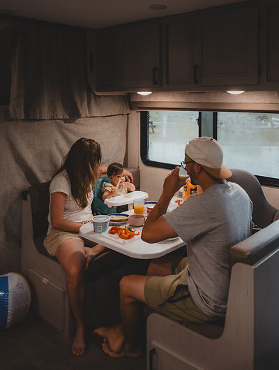 Een gezin zit aan tafel in een camper