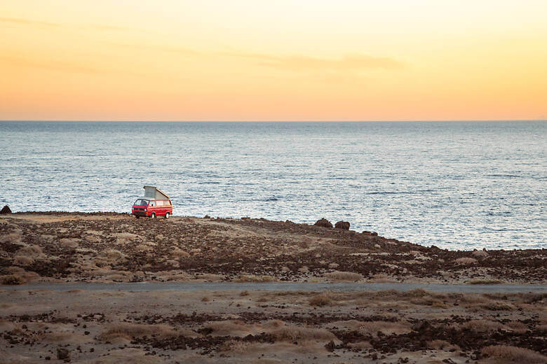 Van an Küste am Meer bei Dämmerung am Meer mit orangenem Himmel
