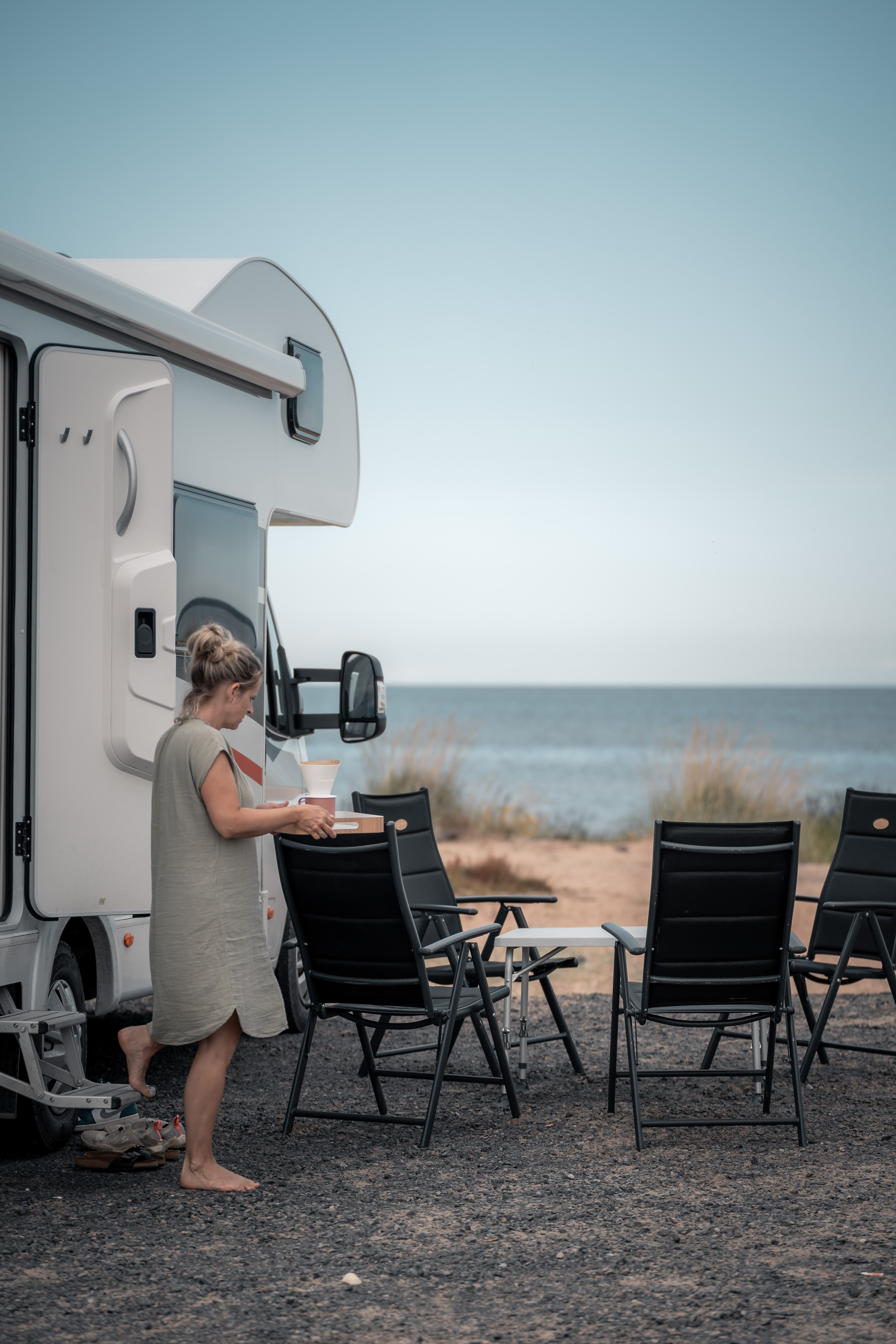Frau am Strand in Finnland mit Wohnmobil