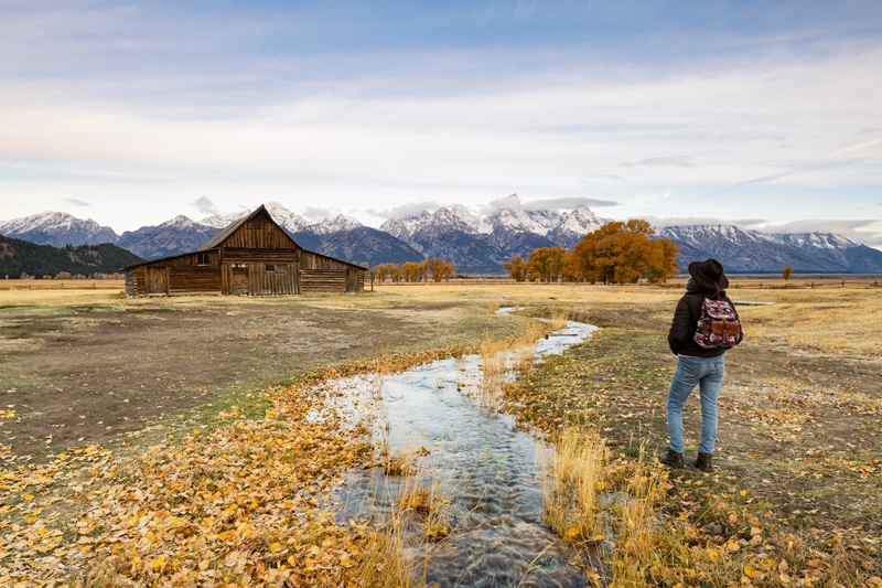 Frau mit Rucksack schaut auf die Rocky Mountains in Montana