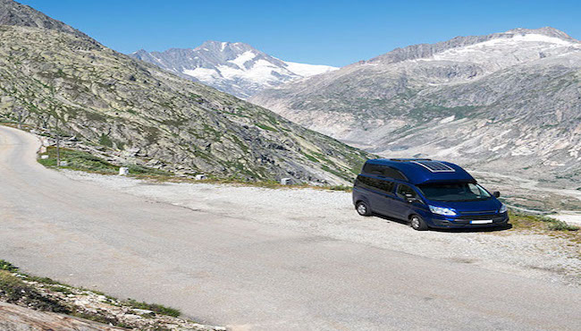 Ein Kastenwagen steht in einer Parkbucht an einer Panoramastraße