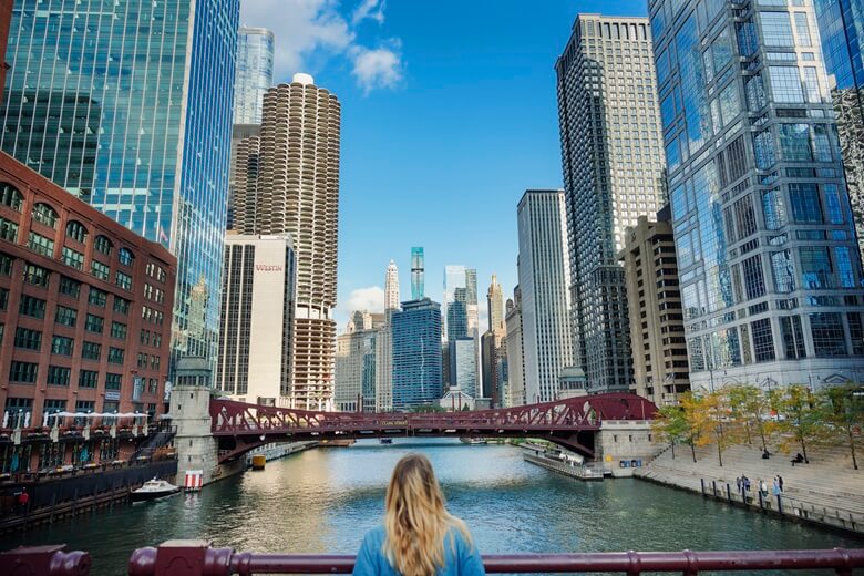 Frau blickt auf den Chicago River und die Wolkenkratzer
