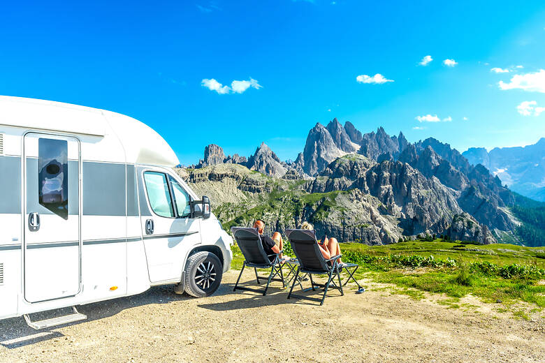 Paar campt mit dem Wohnmobil in den italienischen Alpen