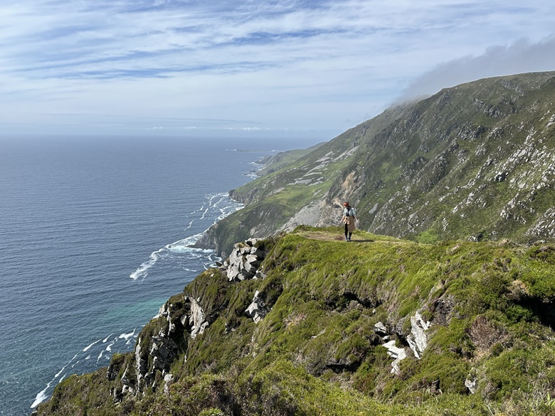 Frau wandert auf den Slieve League Cliffs und schaut auf das Meer