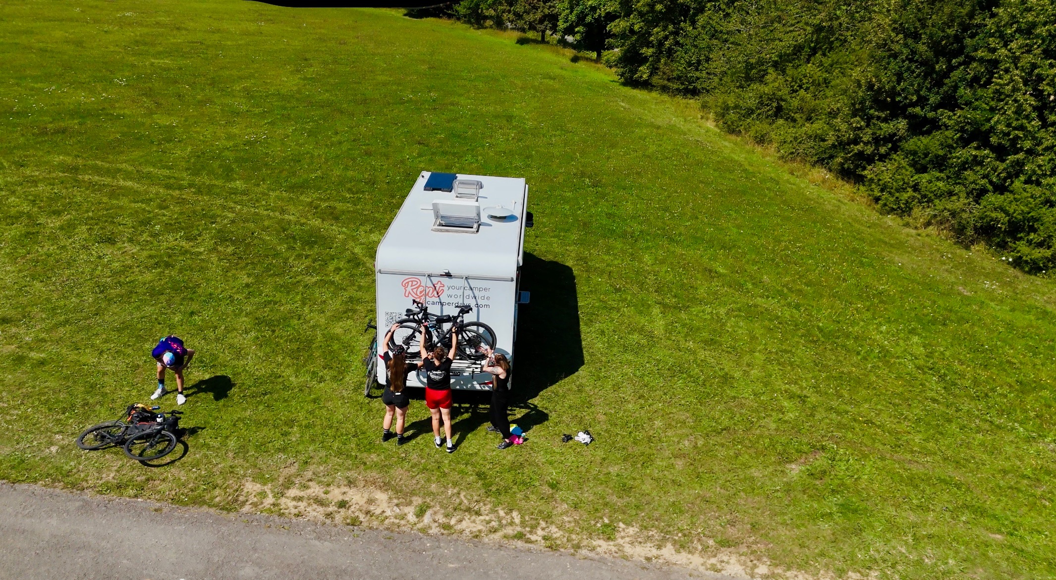 Personen heben Fahrräder auf Wohnmobil
