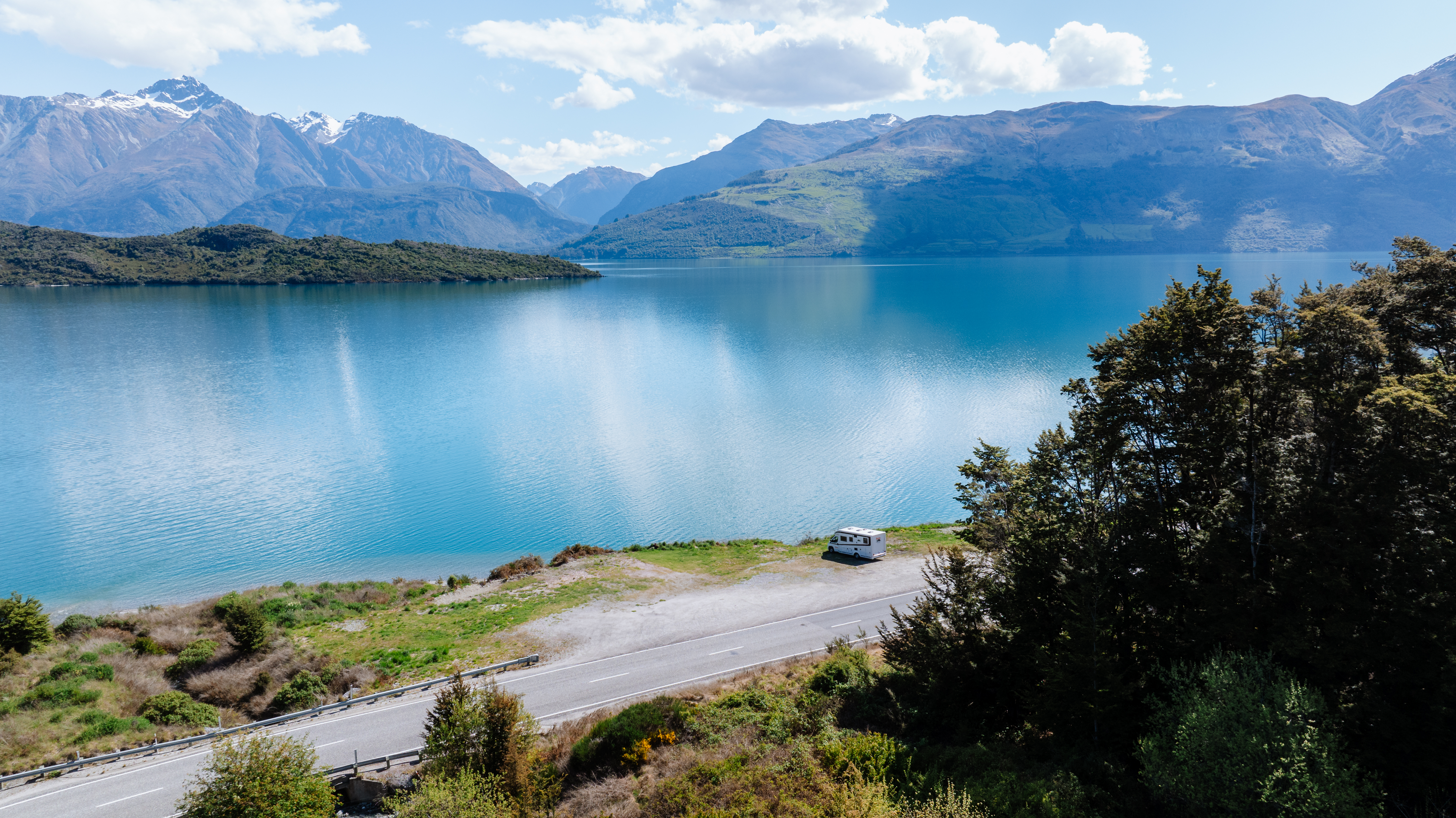 Camper geparkeerd aan Lake Wakatipu in Nieuw-Zeeland, met uitzicht op de bergen