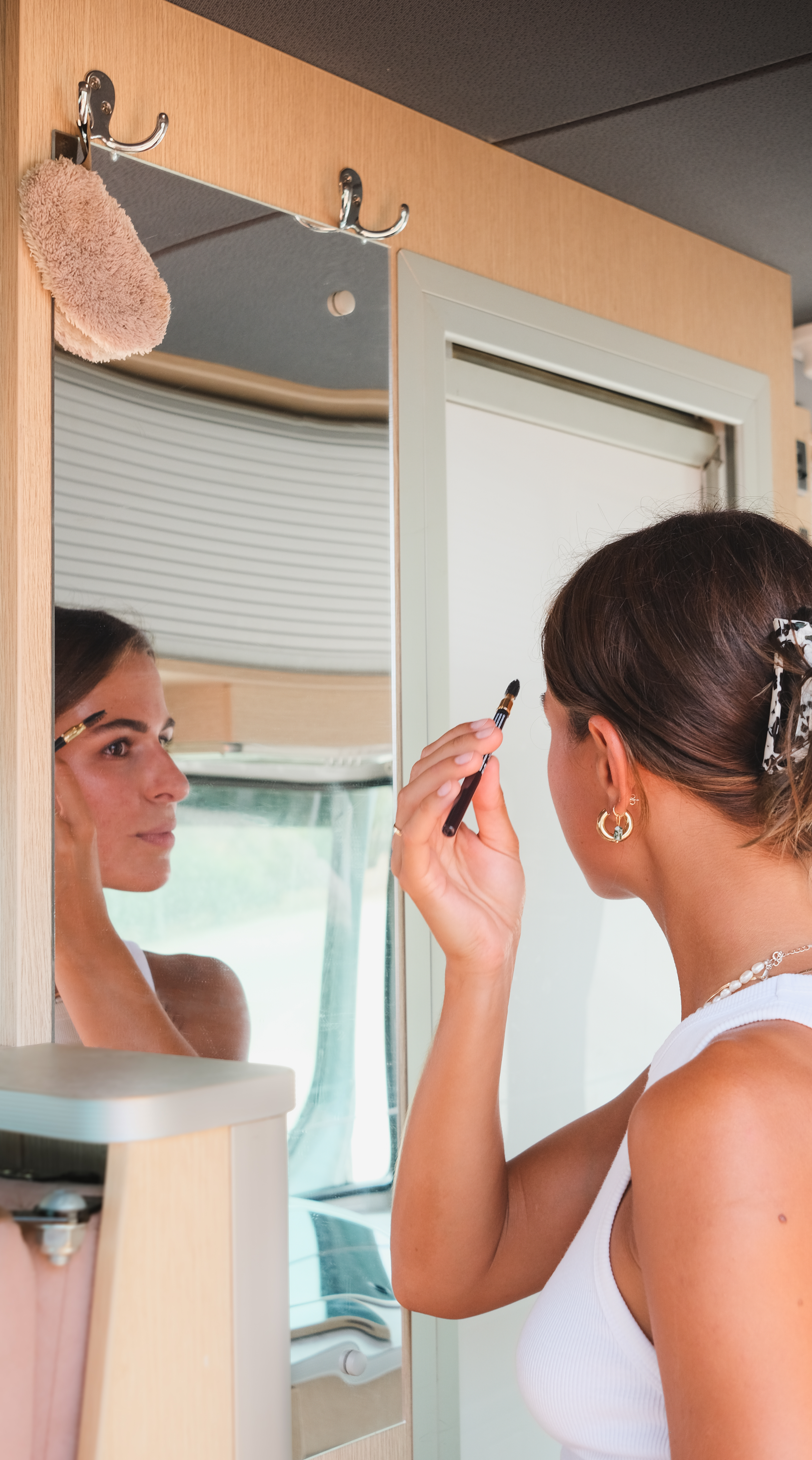 Frau schminkt sich im Wohnmobil-Bad