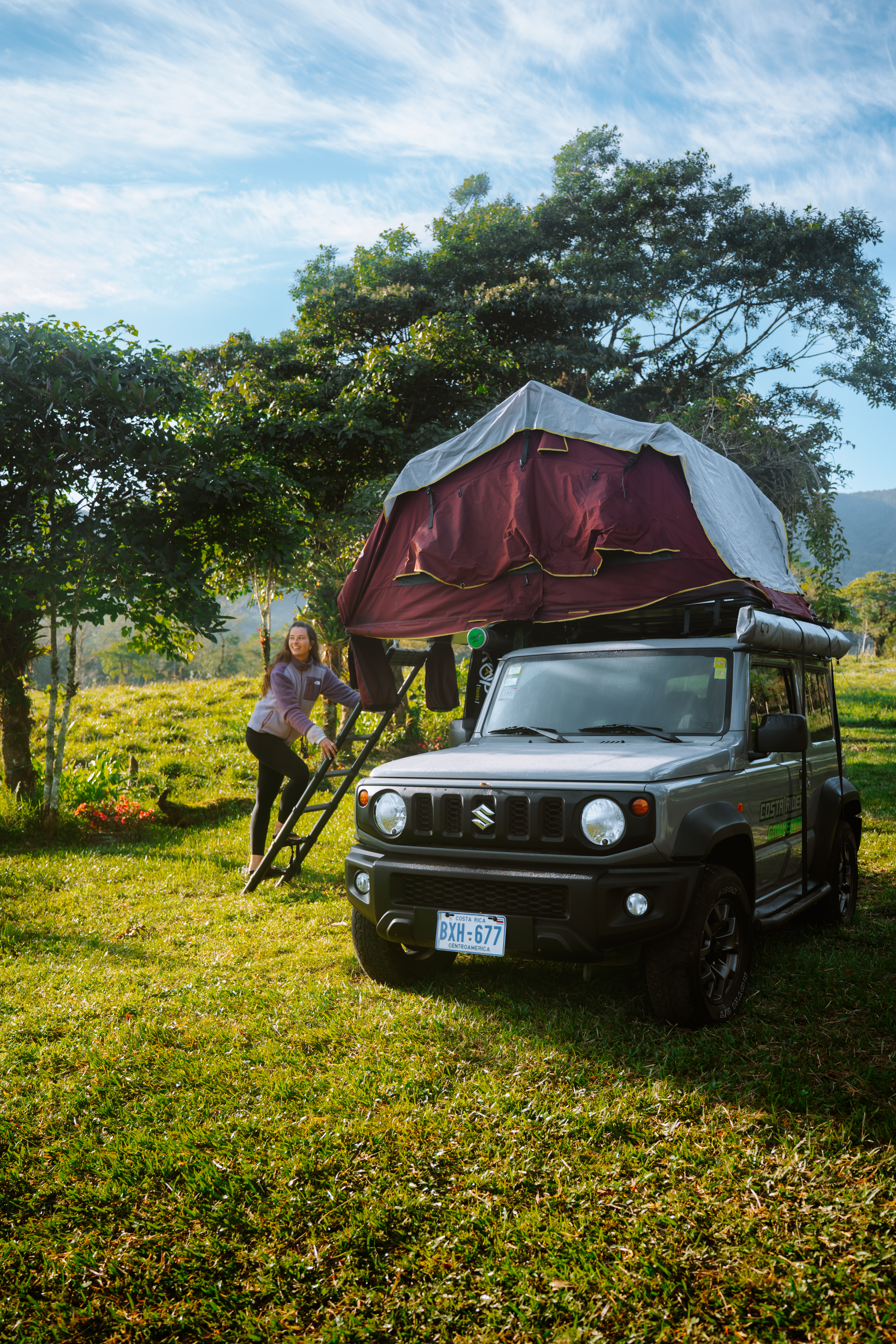 Frau steigt in Allrad-Camper mit Dachzelt