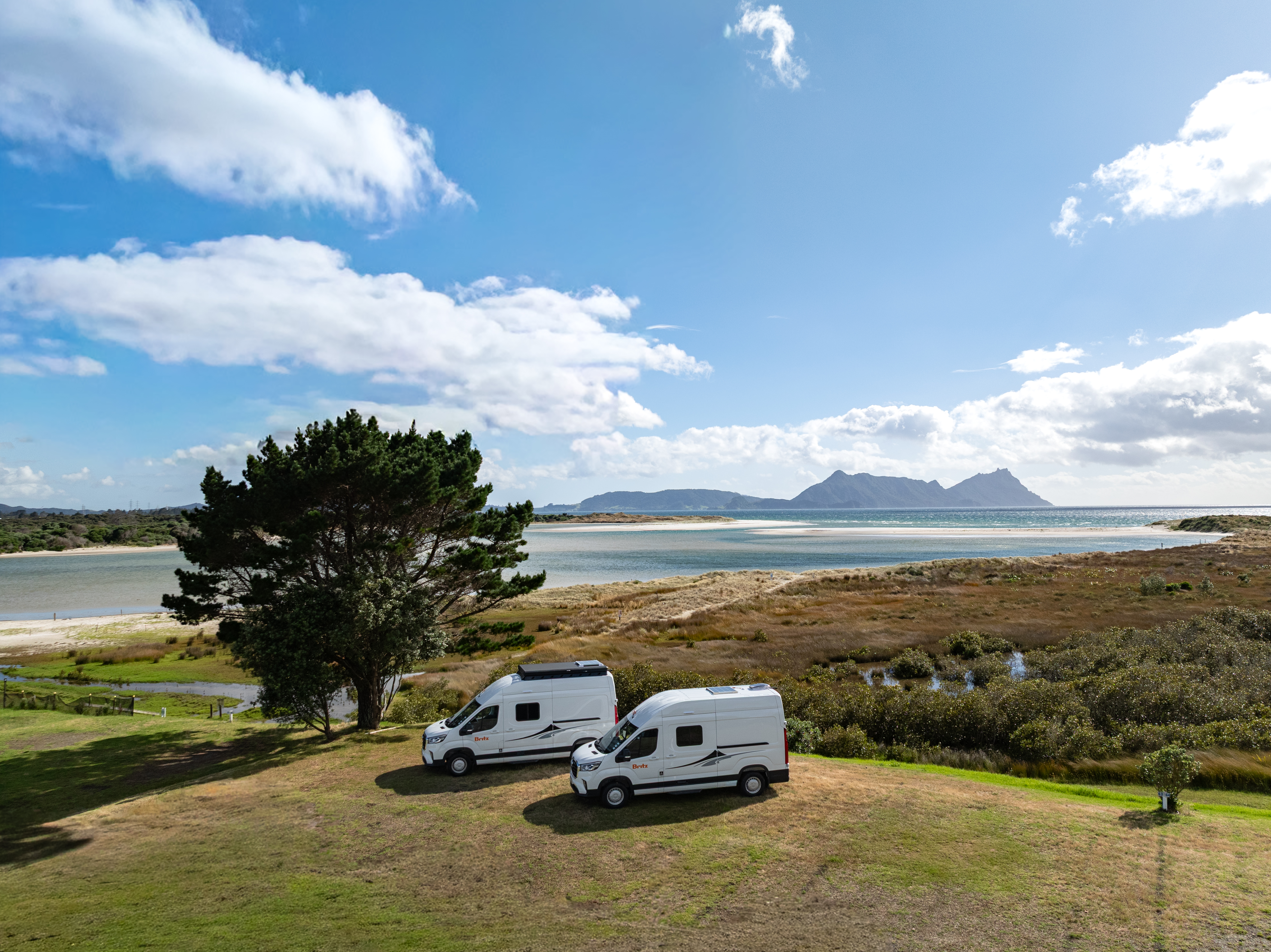 Wohnmobile auf der Nordinsel Neuseelands mit Blick auf das Meer