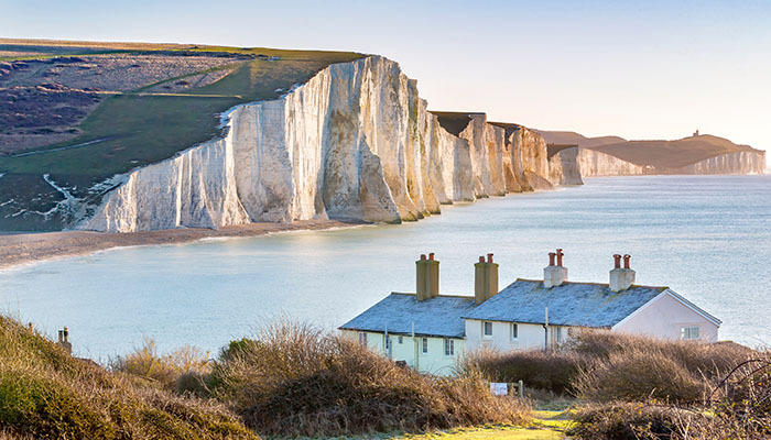 The Coast Guard Cottages and Seven Sisters Chalk Cliffs in Eastbourne, Sussex, England, UK.