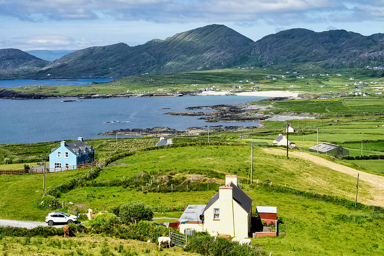 Häuser am Meer und berge am Horizont in Irland