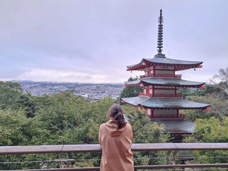 Frau steht neben einer Pagode in Japan und schaut in die Ferne