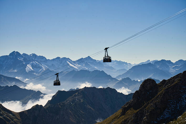 Blick über die Alpen mit Gondeln im Vordergrund 