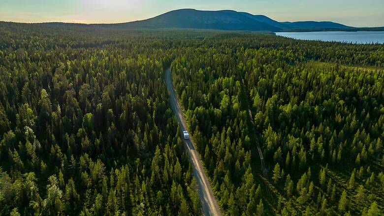 Wohnmobil fährst durch Waldlandschaft in Finnland