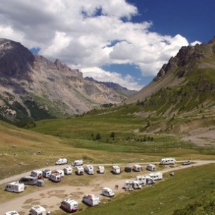 Parcela de autocaravana frente a un escenario de montaña en el Col du Lautaret