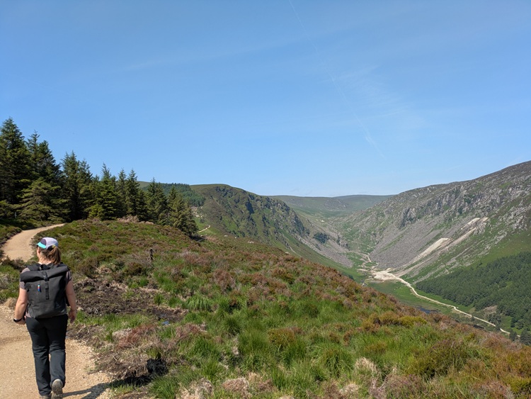 Frau wandert im Wicklow Mountains National Park in Irland mit Blick auf die Berge