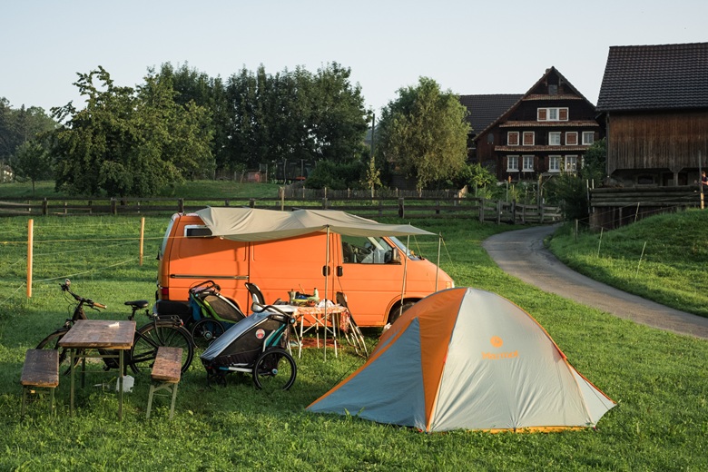 Campervan und Zelt auf einem Bauernhof