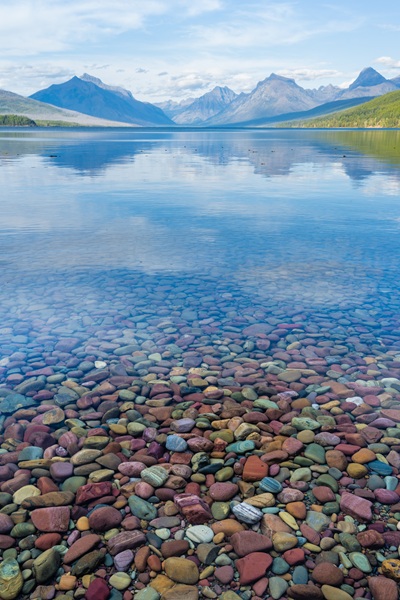 Glasklarer See mit bunten Steinen im Glacier National Park
