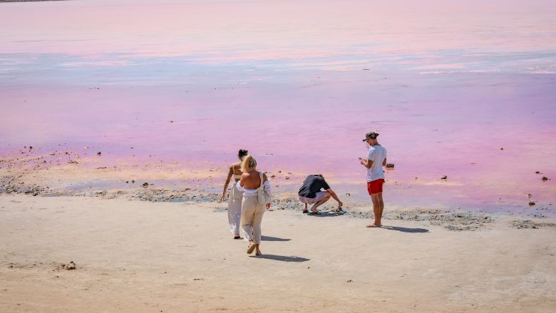 Vier mensen aan een roze meer in Australië