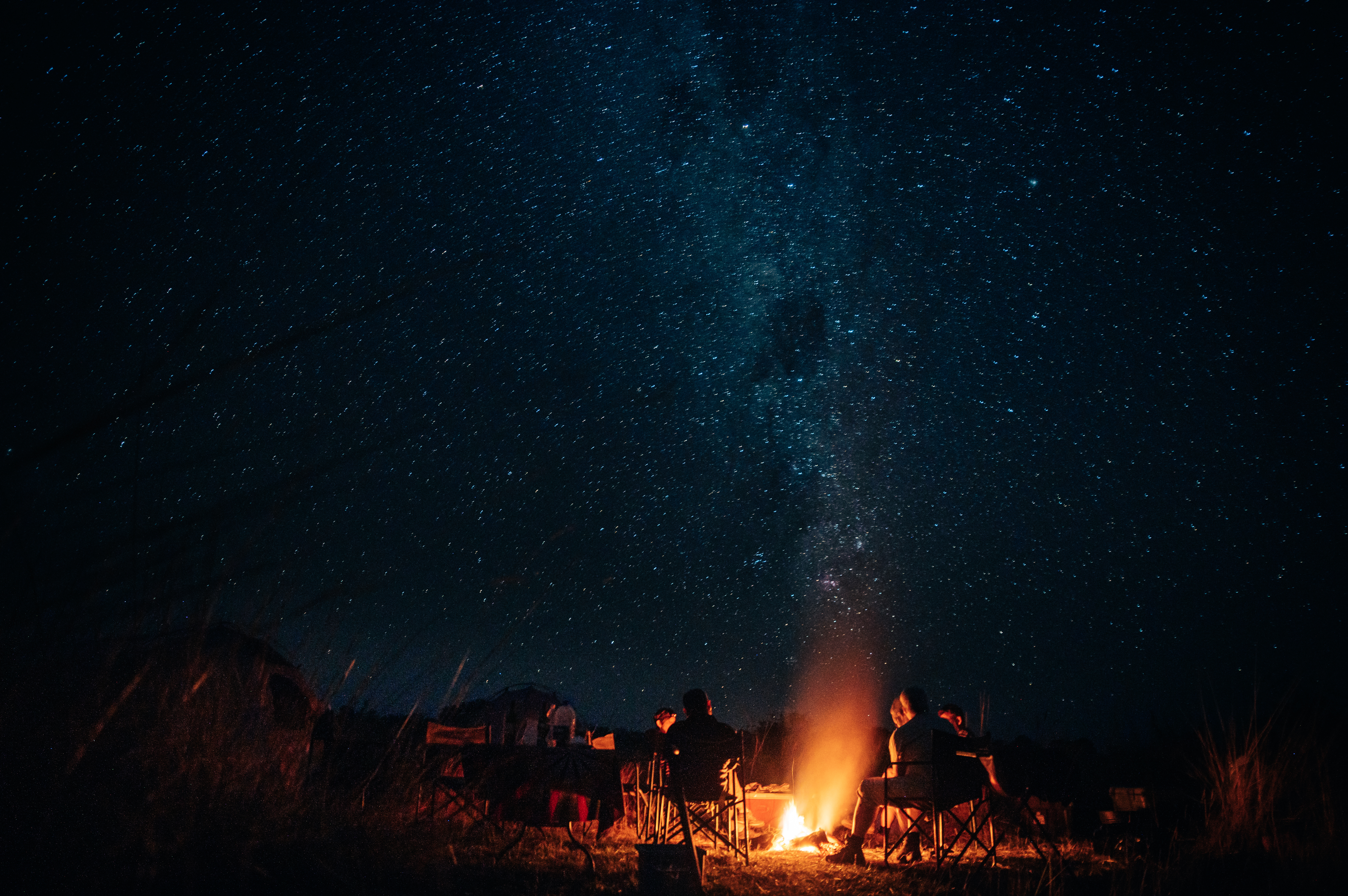 Menschen campen in der namibischen Wüste unter dem Sternenhimmel 