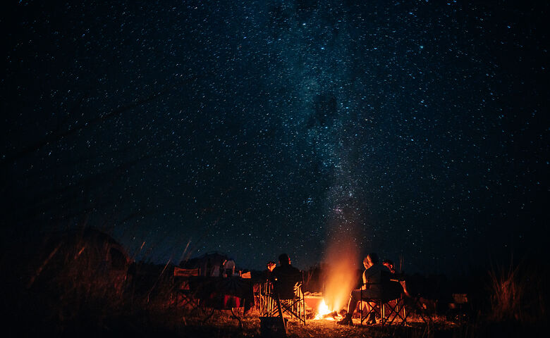 Menschen campen in der namibischen Wüste unter dem Sternenhimmel