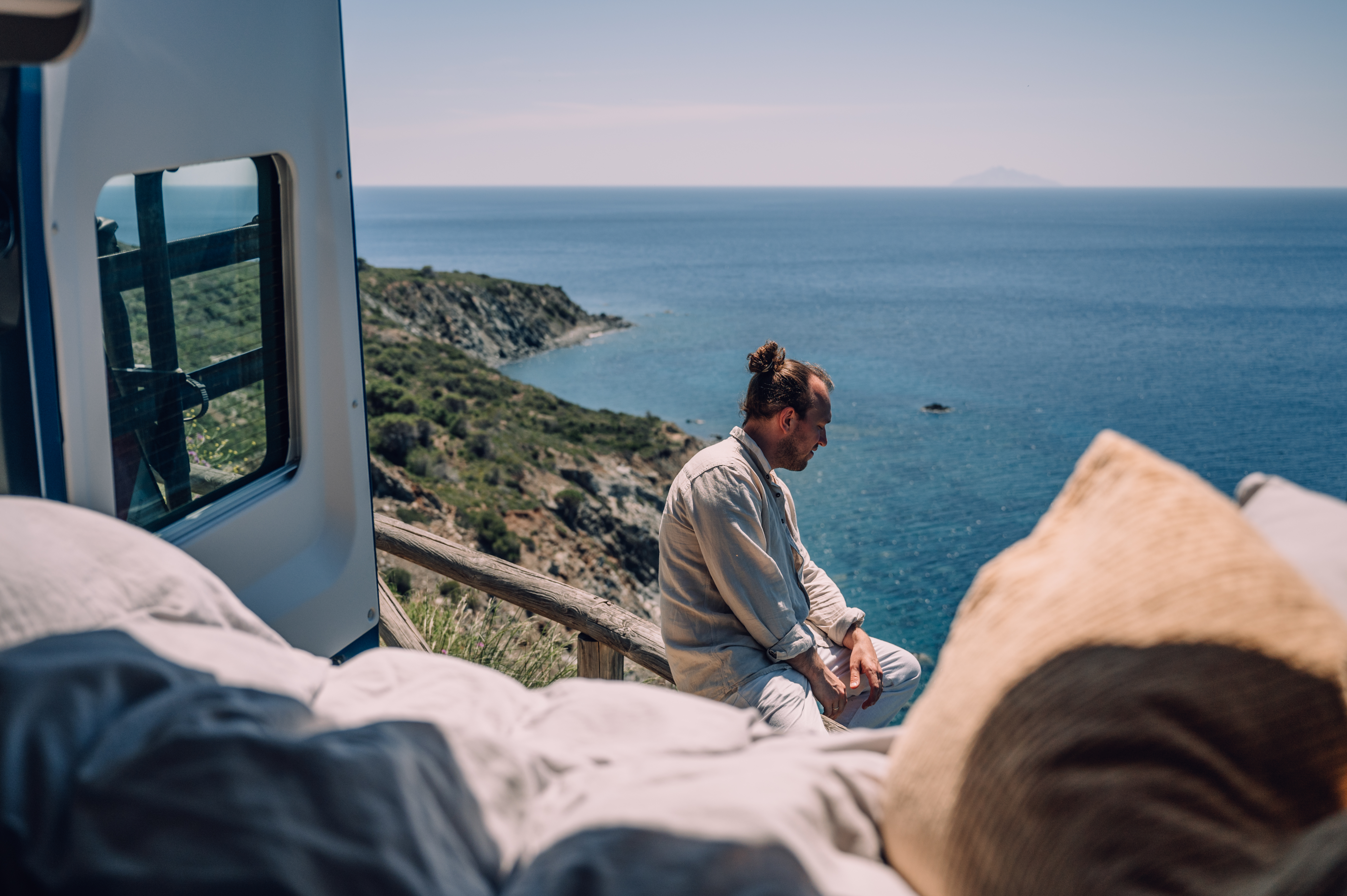 Mann campt in Italien mit Blick auf das Meer