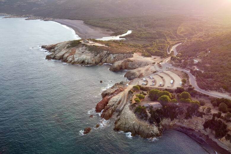 Wohnmobile campen auf einem Felsplateau am Meer auf Korsika
