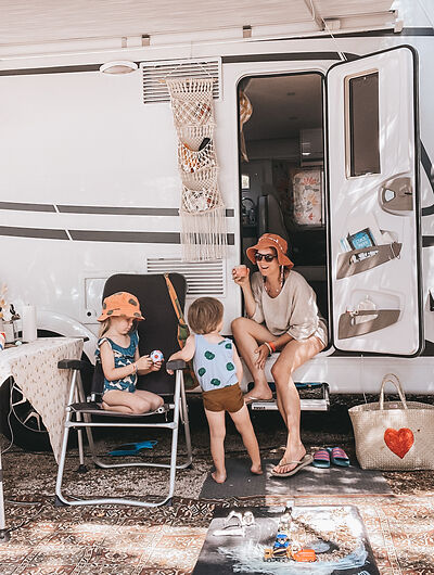 Vrouw met kinderen voor de camper