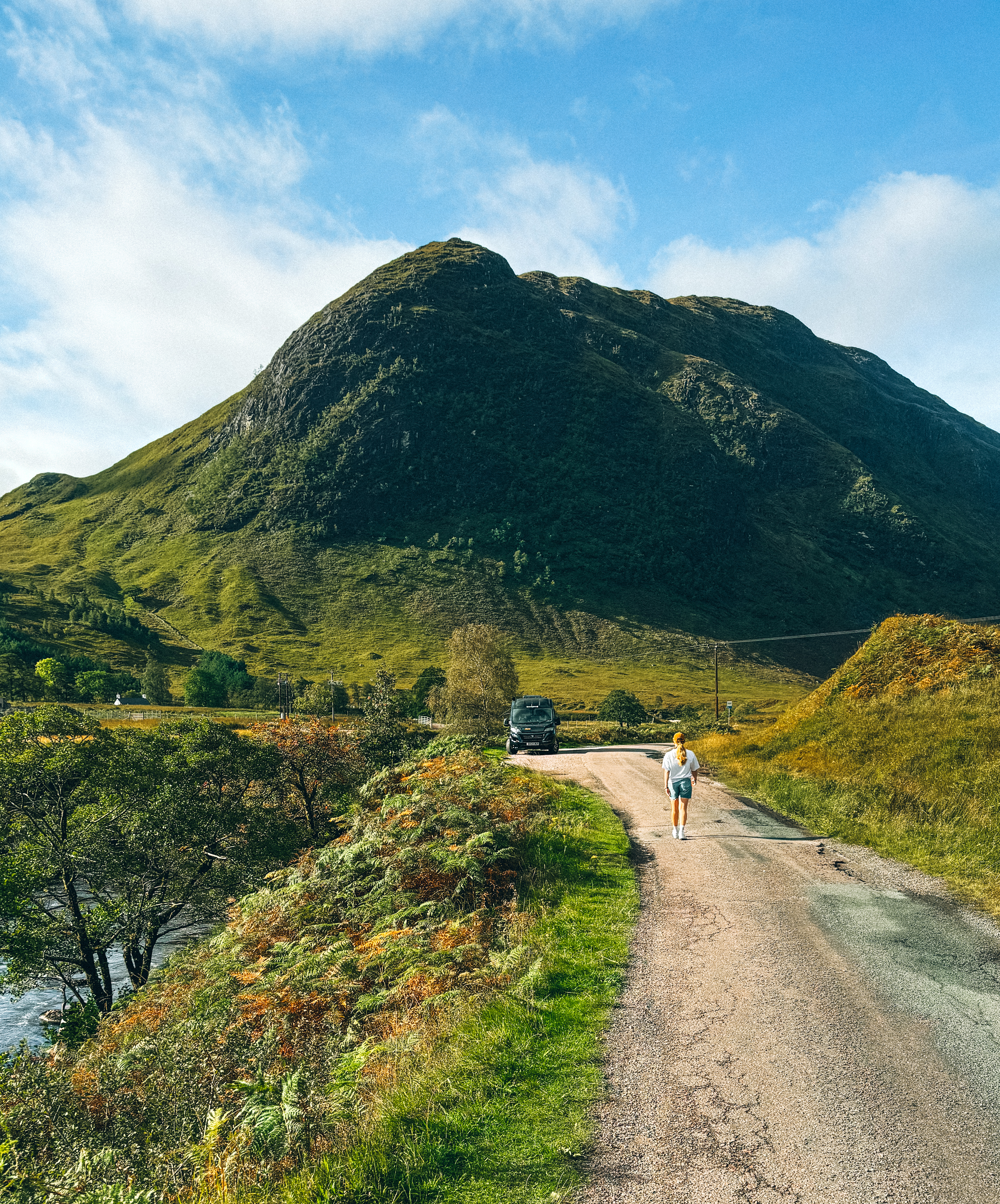 Frau in schottischer Landschaft mit Camper