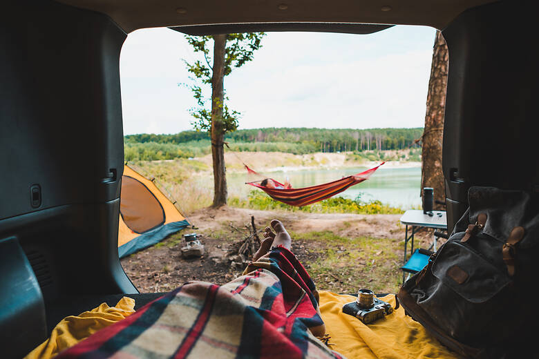 Blick aus dem Camper auf eine Hängematte am See 