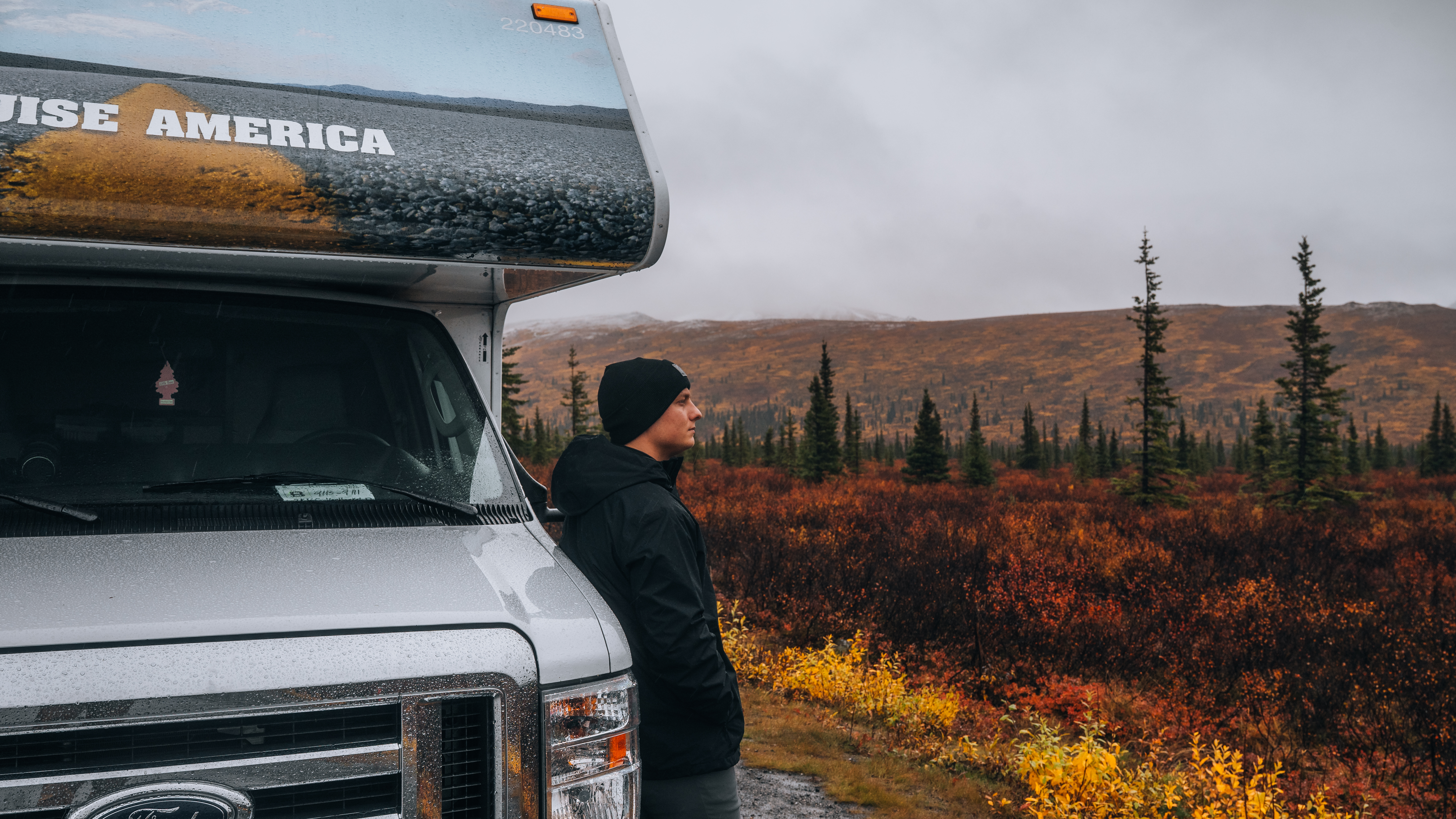 Mann lehnt an Wohnmobil in Alaska