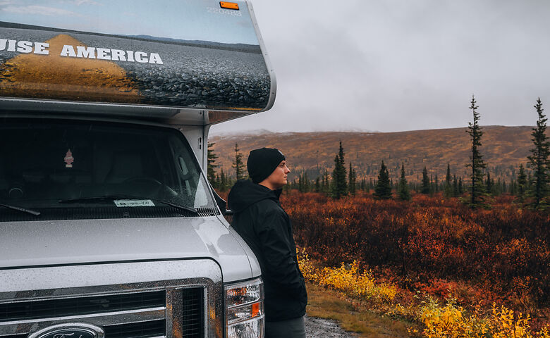 Mann lehnt an Wohnmobil in Alaska