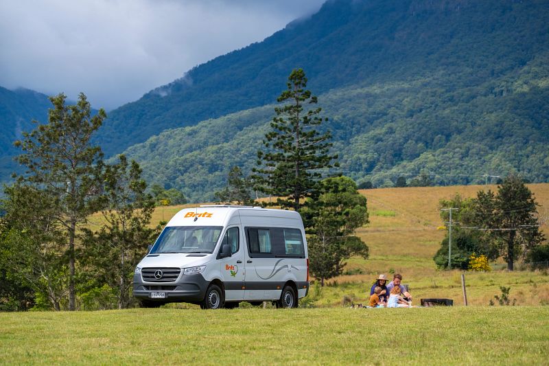 Familie und Britz Camper in einer Alpenlandschaft