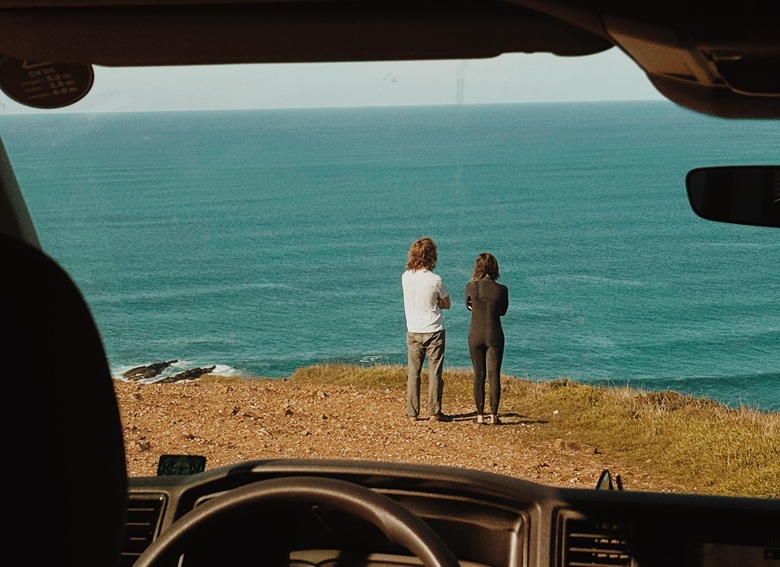 Blick aus dem Camper auf zwei Menschen, die am Meer stehen