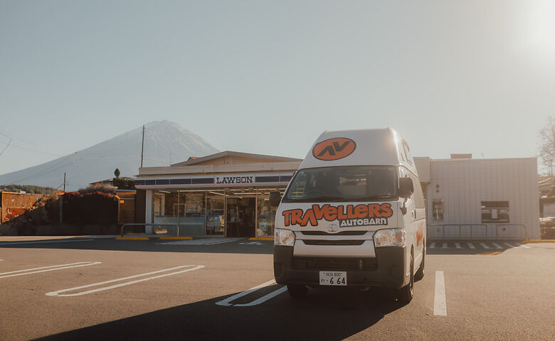 Camper steht in Japan vor einem Lawson-Supermarkt