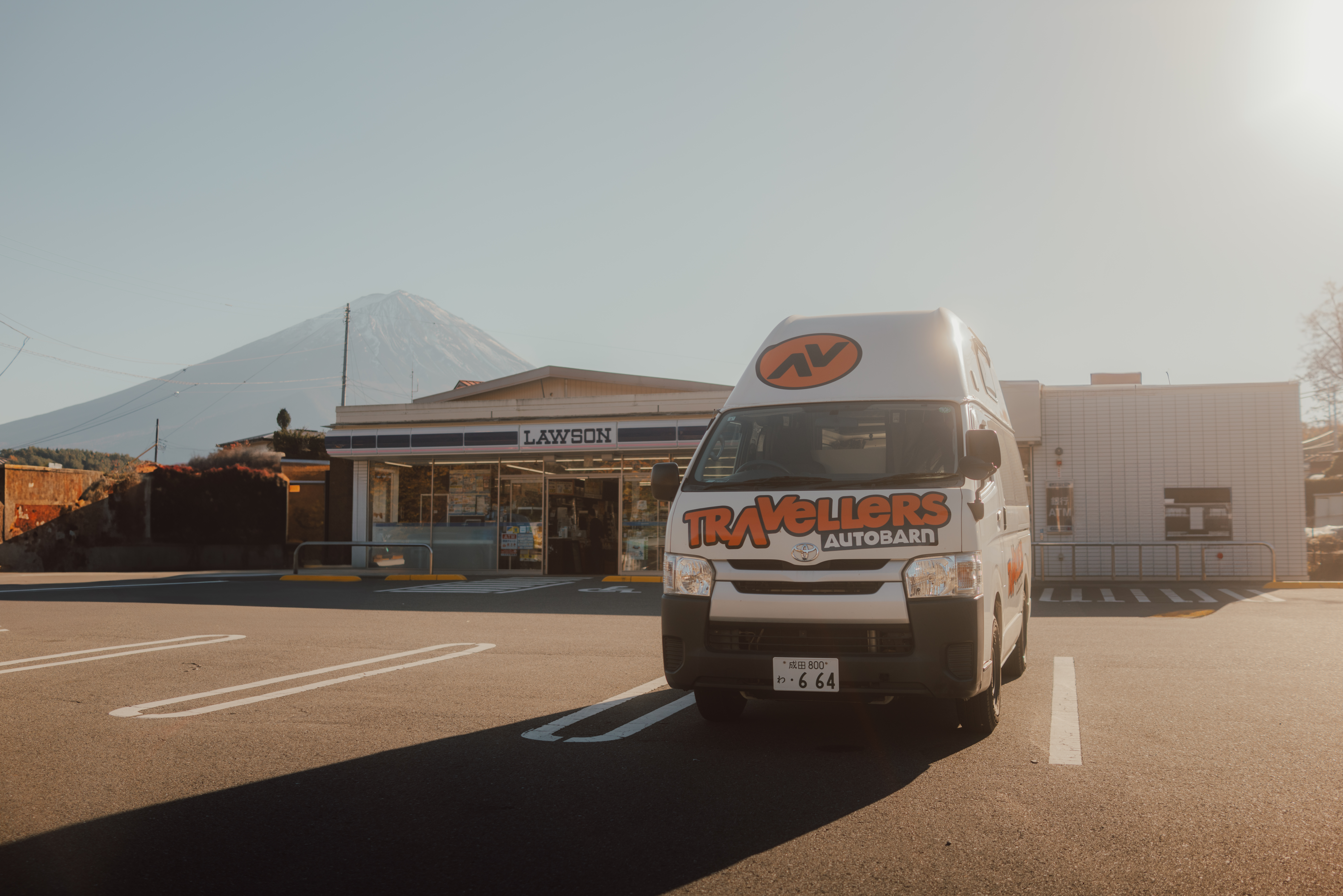 Camper steht in Japan vor einem Lawson-Supermarkt