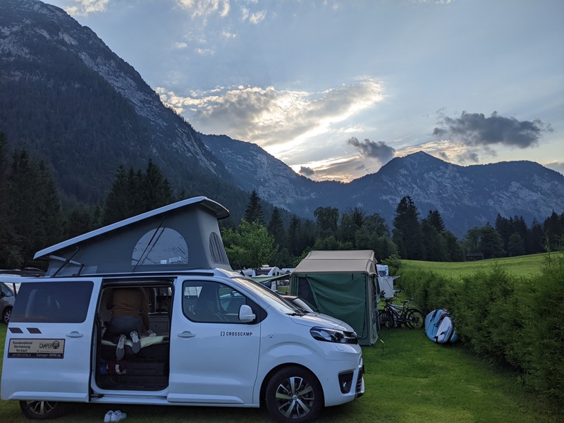Camper mit Dachzelt auf einem Campingplatz in den Alpen