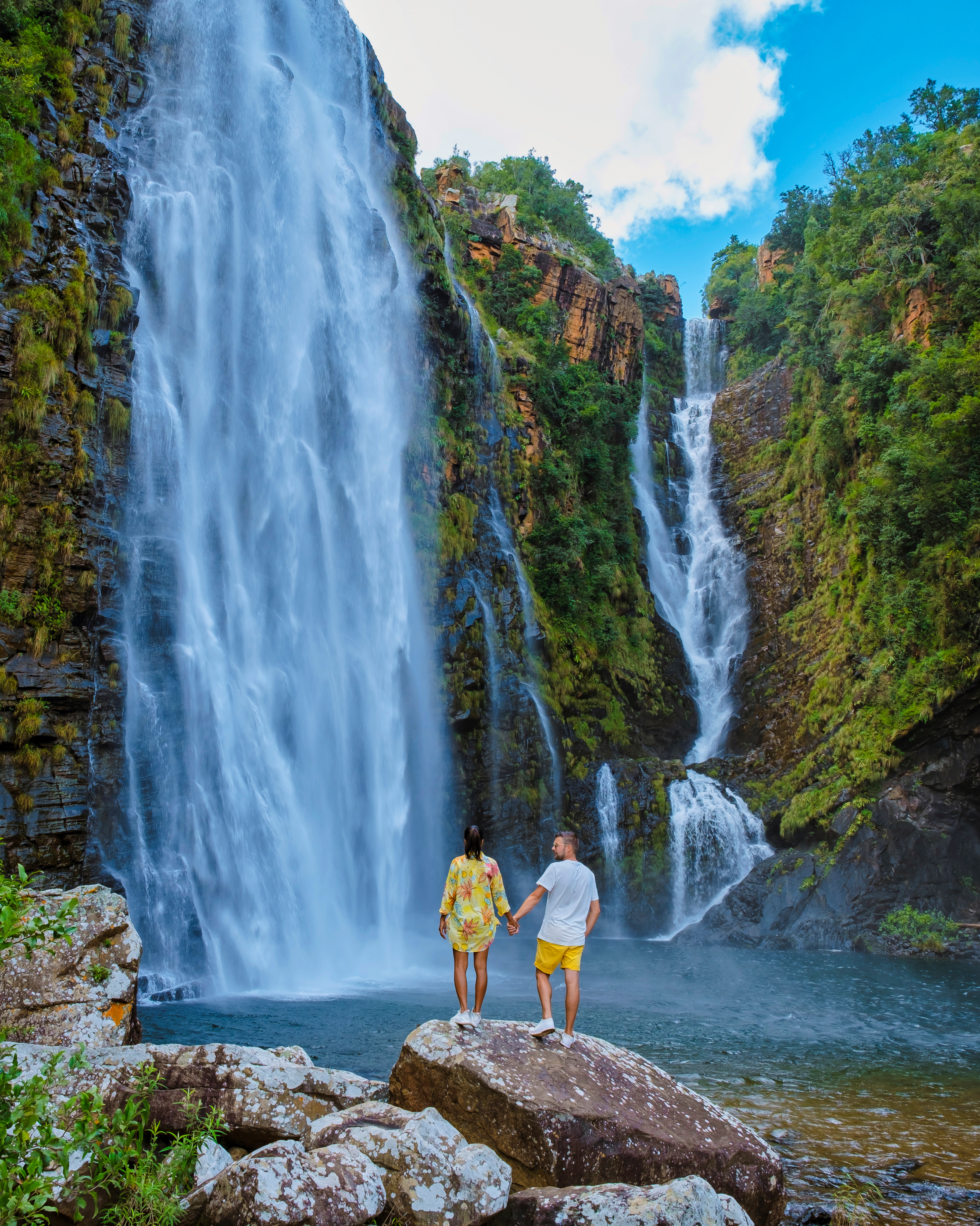 Zwei Personen an einem Wasserfall in Südafrika (Panoramaroute)