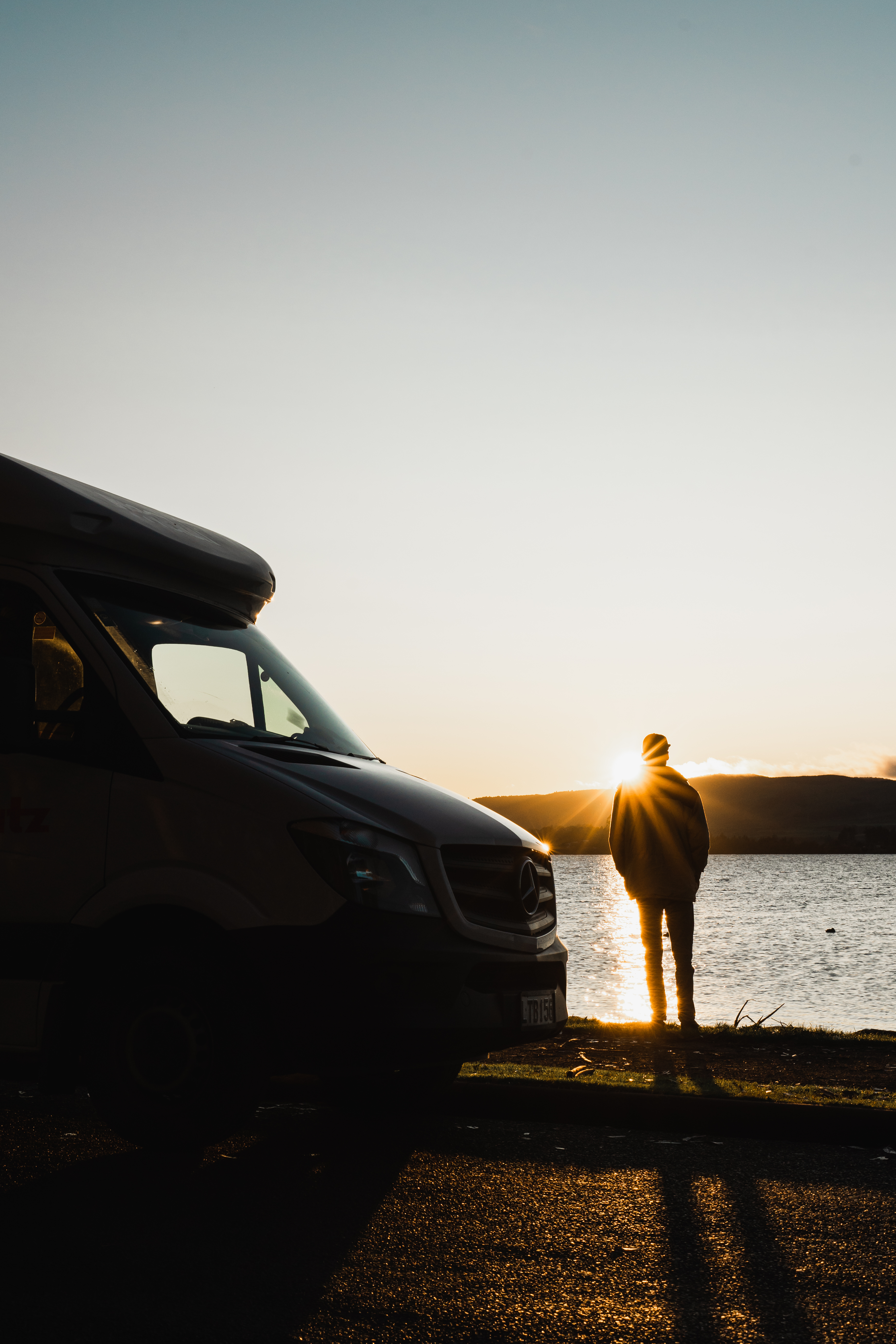 Mann steht am Lake Rotorua bei Sonnenuntergang in Neuseeland