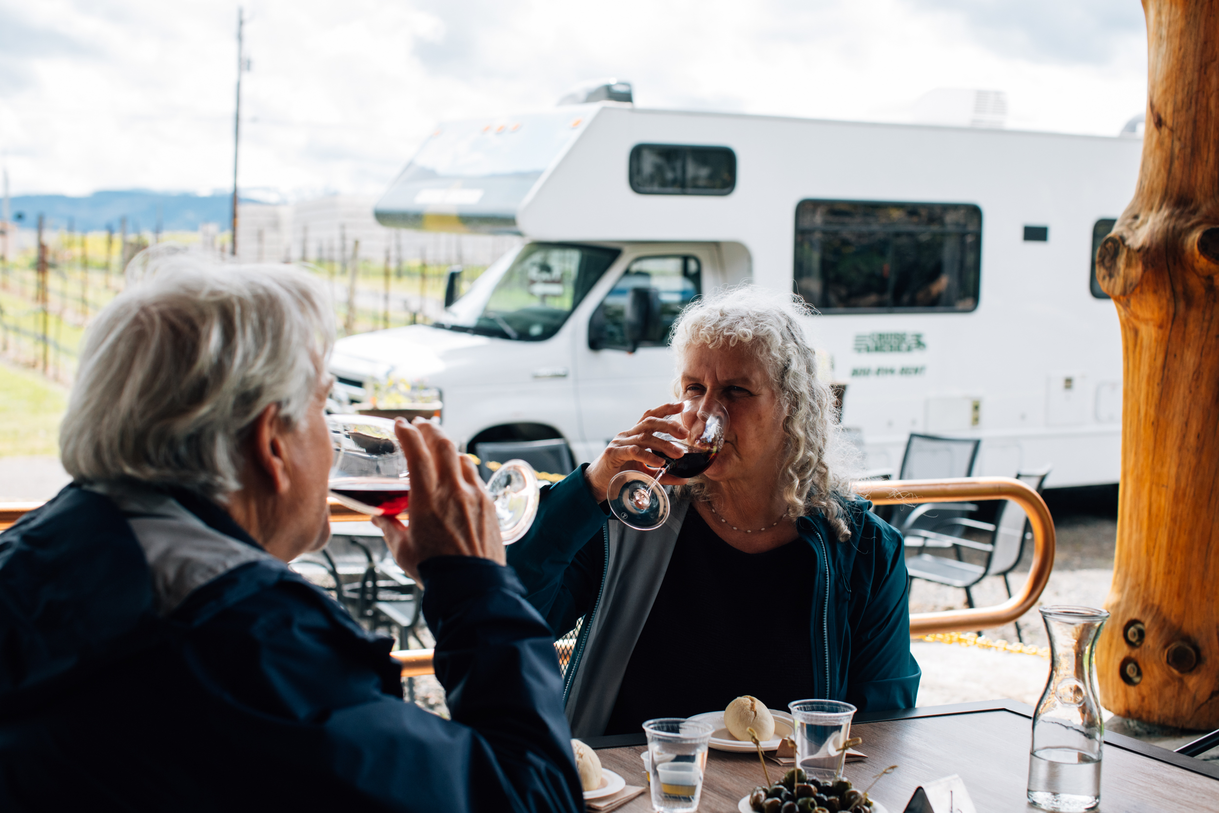 Senioren trinken ein Glas Wein vor dem Wohnmobil